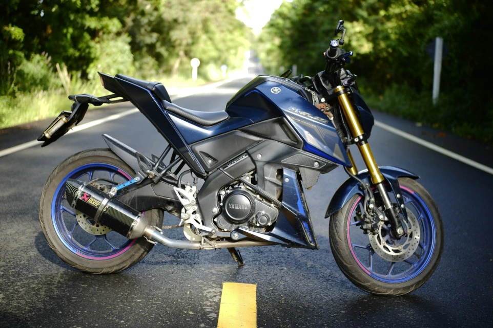 black and silver sports bike parked on gray asphalt road during daytime